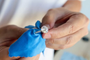 Hands cleaning a diamond ring
