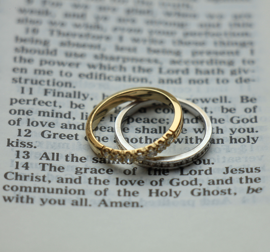 His and hers wedding bands resting on the pages on an open bible