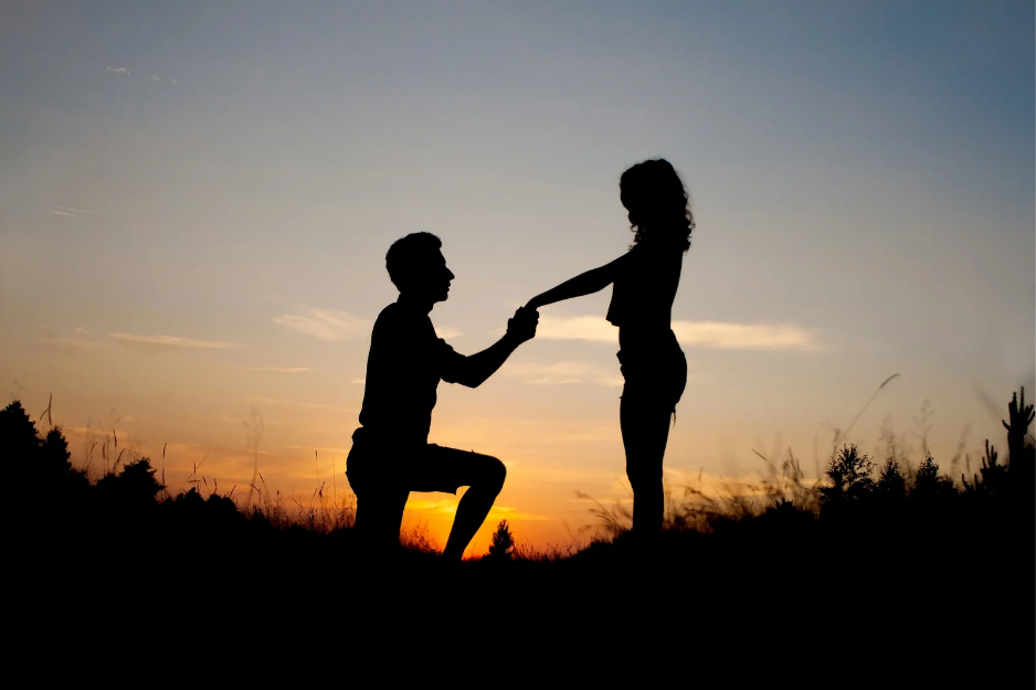 Man on one knee prosing with ring to fiancée 