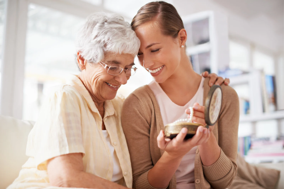 Grandmother handing family heirloom pearl necklace to  granddaughter 