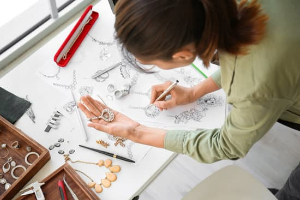 Designer sketching jewellery with tools on a desk