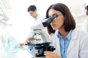 Scientist checking lab grown diamond under microscope 