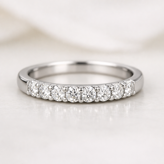 Close-up of a pre-owned white gold eternity band ring with pavé-set diamonds across the top, photographed on a soft neutral background.