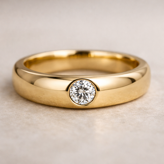Close-up of a yellow gold engagement ring with a round diamond on a neutral background