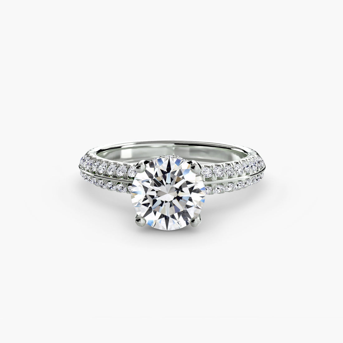 Close-up of a round brilliant diamond engagement ring with a pave band on a neutral background.