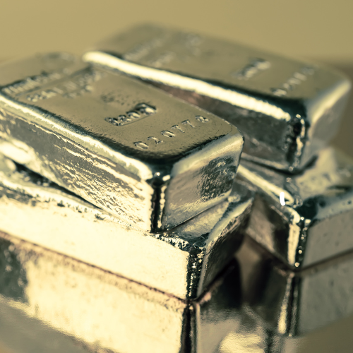 Stack of platinum bars on a reflective surface, symbolising precious metal types for jewellery.