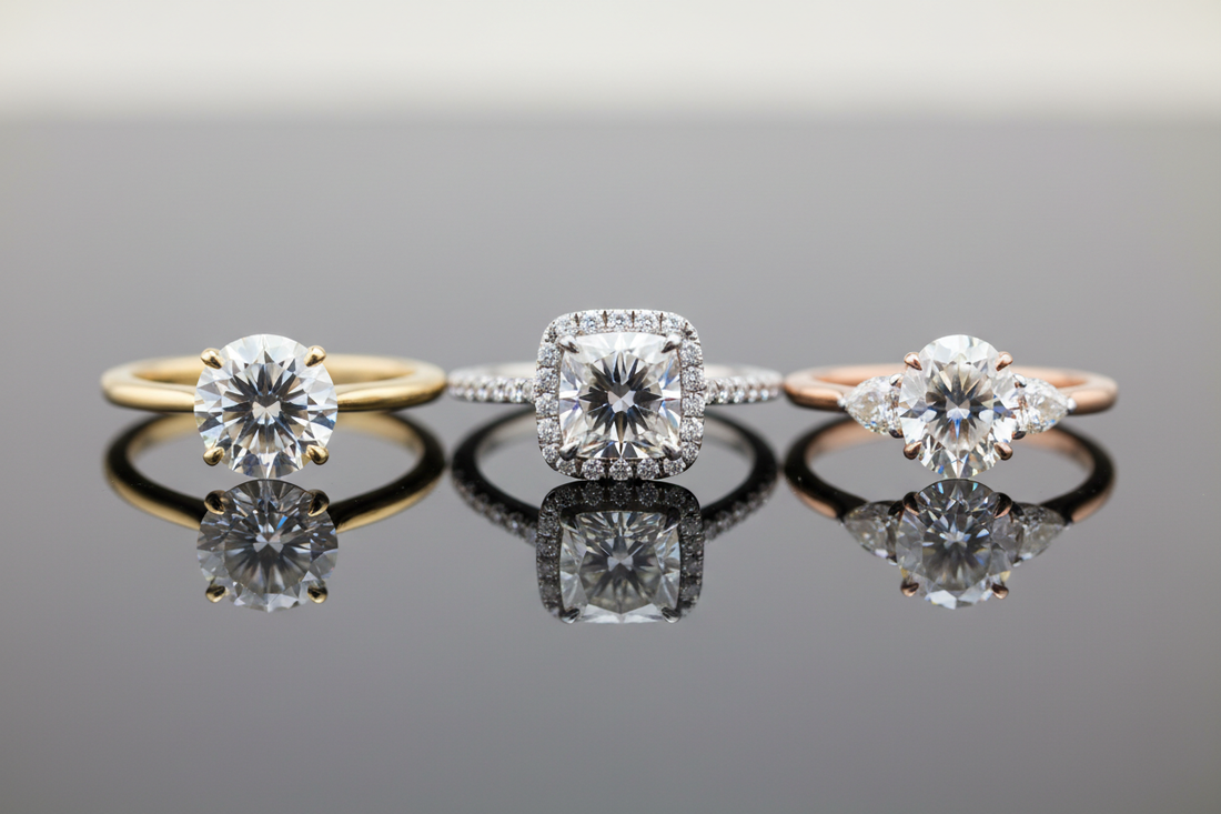 Row of gold, rose gold and platinum engagement rings with round diamonds on a reflective surface