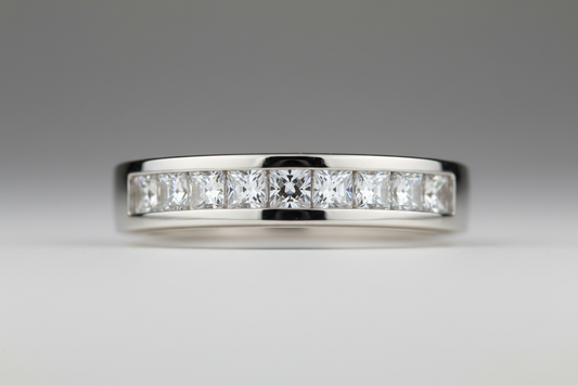 Close-up of a bezel-set diamond engagement ring under soft studio lighting